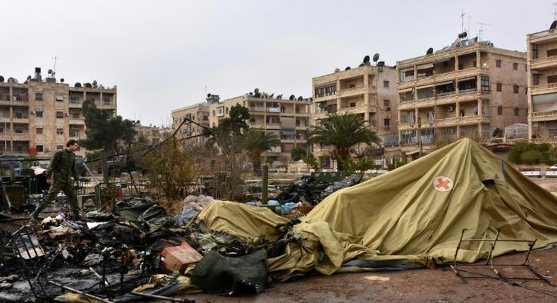 A Russian soldier inspects the damage at a field hospital that was reportedly destroyed by rebel shelling in the Furqan neighbourhood of the government-held side of west Aleppo