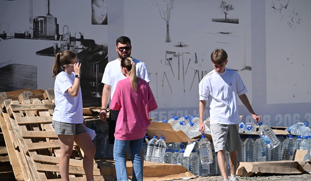 Lokalni stanovnik nosi flaše sa vodom za piće iz humanitarne pomoći koju su dopremili volonteri u Džankoju na Krimu