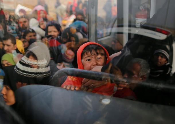 Iraqi people flee the Islamic State stronghold in the town of Bartella