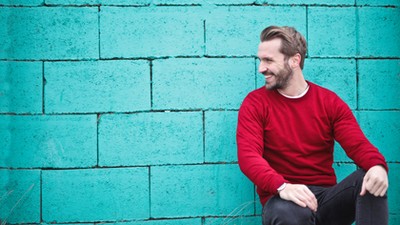 man-wearing-red-sweatshirt-and-black-pants-leaning-on-the-845434