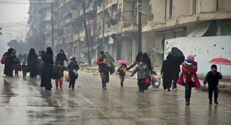 People leave a rebel-held area of Aleppo towards the government-held side on December 13, 2016