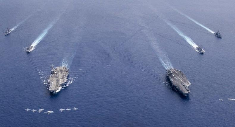 Aircraft from Carrier Air Wing 5 and Carrier Air Wing 17 fly in formation over the Nimitz Carrier Strike Force (CSF). The USS Nimitz (CVN 68) and USS Ronald Reagan (CVN 76) Carrier Strike Groups are conducting dual carrier operations in the Indo-Pacific as the Nimitz CSF.