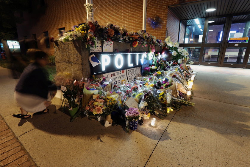 Fredericton residents pay their respects at a makeshift shrine in front of police headquarters