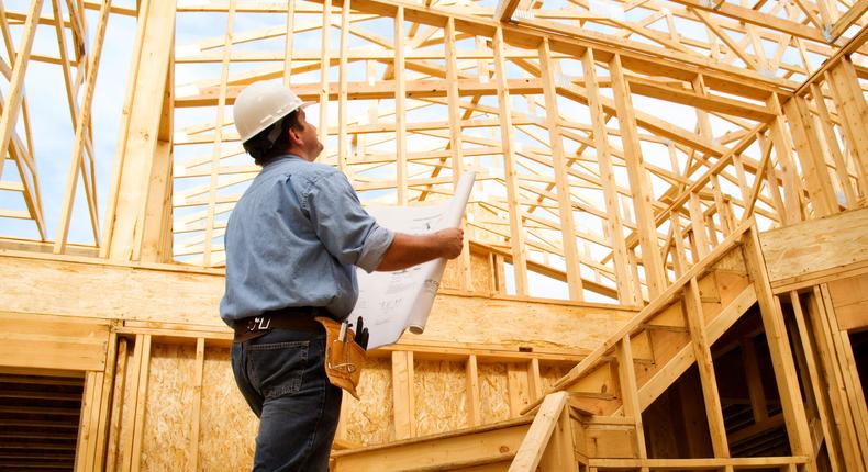 Construction worker observing a house.