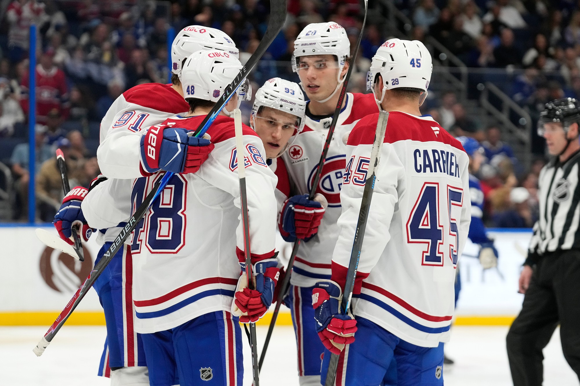 Juraj Slafkovský so spoluhráčmi z Montrealu Canadiens oslavuje gól. 