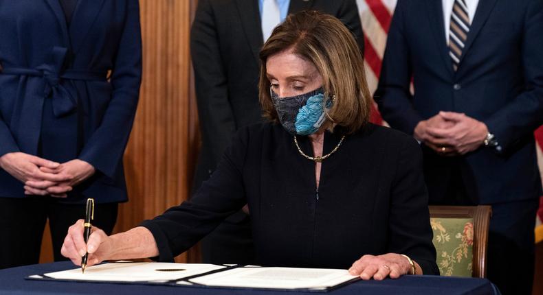 House Speaker Nancy Pelosi of Calif., holds the article of impeachment against President Donald Trump after signing it, in an engrossment ceremony before transmission to the Senate for trial on Capitol Hill, in Washington, Wednesday, Jan. 13, 2021.