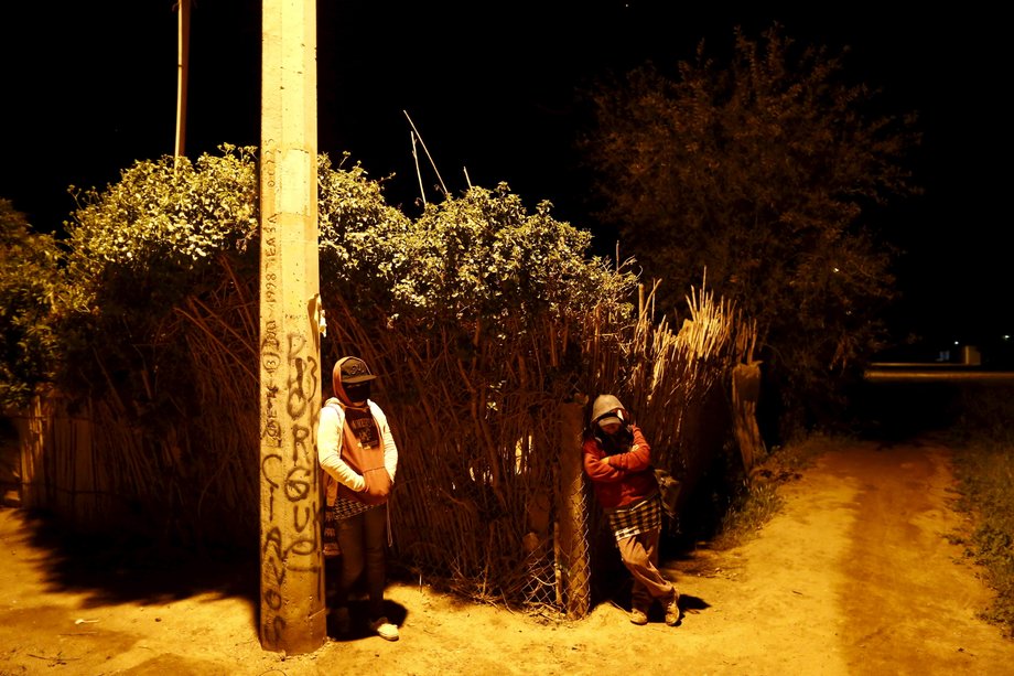 Produce pickers wait for a bus as they travel to work in a neighborhood in San Quintin in Baja California state, Mexico, March 31, 2015.