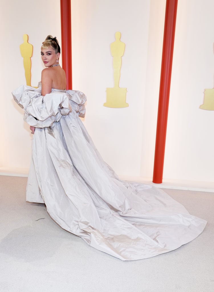 Florence Pugh az Oscar gála alkalmából köpenyruhája olyan, mintha egy jelmezes filmből lépett volna elő a színésznő. Bezzeg ha megfordul!