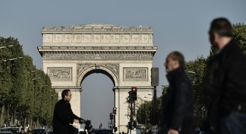 Pedestrians and vehicles on the Champs-Elysees in Paris on April 21 ,2017, a day after a gunman opened fire on police on the avenue, killing a policeman and wounding two others