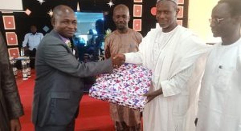 Prof. Isah Mshelgaru, Leader of a Muslim group who celebrate Christmas with Christians at EYN Church, Samaru Zaria, presenting gift to Rev. Tijjani Chindo, during the Christmas service at Zaria on Sunday.
