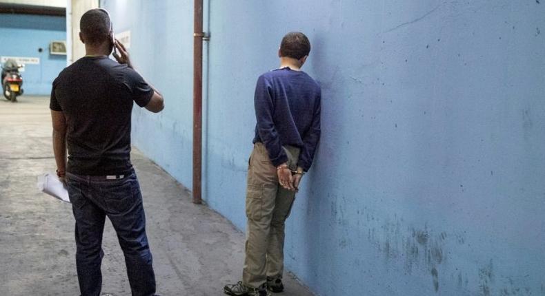 American-Israeli Jewish teenager (R) accused of making of anti-Semitic bomb threats in the US and elsewhere, is escorted outside the Israeli Justice court in Rishon Lezion