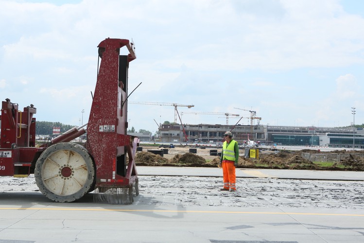 Na pierwszym planie - remontowana droga kołowania (maszyna krusząca starą nawierzchnię), w tle - budowa nowego terminalu (L), zaś z prawej - obecny terminal na lotnisku Kraków-Balice.

<br><br>fot. (dw) PAP/Stanisław Rozpędzik