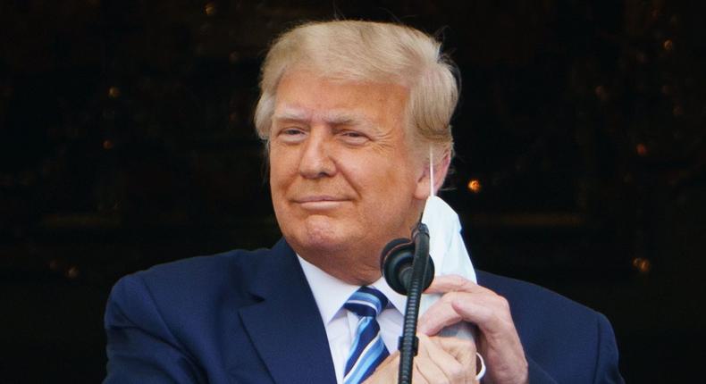 Then-President Donald Trump taking his mask off before speaking at a rally from the South Portico of the White House in Washington, DC on October 10, 2020 shows.