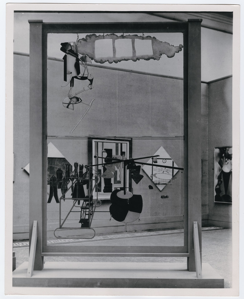 Widok aranżacji "International Exhibition of Modern Art arranged by Société Anonyme" (Brooklyn Museum, 1926). Na pierwszym planie dzieło Marcela Duchampa, "Panna młoda rozebrana przez swych kawalerów, jednak (Wielka szyba)" (1915–1923) usytuowane w sali głównej