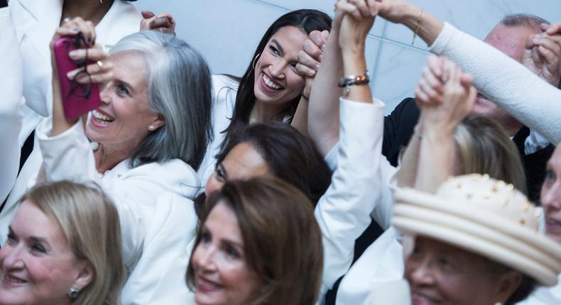 Rep. Alexandria Ocasio-Cortez, D-N.Y., top center, and Speaker Nancy Pelosi, D-Calif., bottom center, pose for a group photo of House Democrats in the Capitol Visitor Center, who plan to wear 'suffragette white' to the State of the Union address to show solidarity for women's agendas on Tuesday