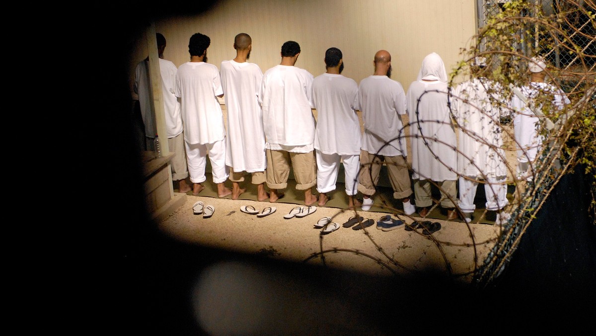 File photo of detainees observing morning prayer before sunrise inside Camp Delta at Guantanamo Bay naval base