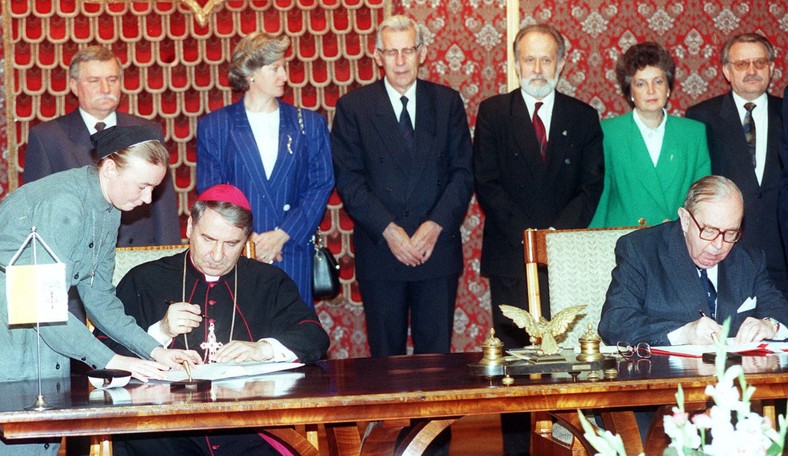 Konkordat w przededniu wymiany dokumentów w Watykanie, zdjęcie archiwalne z 28 lipca 1993 R., podpisują: nuncjusz apostolski abp Józef Kowalczyk, min. spraw zagranicznych Krzysztof Skubiszewski, stoją: prezydent Lech Wałęsa, premier Hanna Suchocka, marszałek Sejmu Wiesław Chrzanowski, marszałek Senatu August Jan Chełkowski, wicemarszałek Senatu Alicja Grześkowiak, wicepremier Henryk Goryszewski