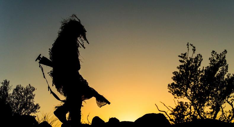 A Special Operations Command sniper walks a ridge line during a special reconnaissance mission.