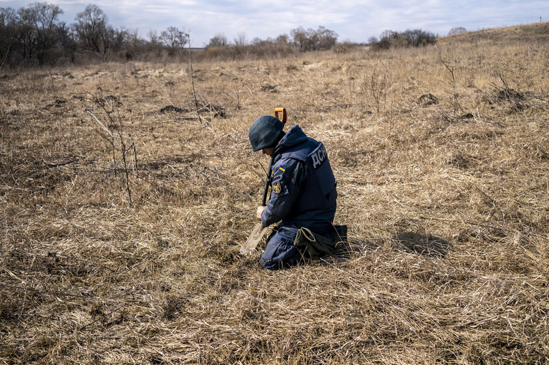 Członek zespołu Państwowej Służby Ratowniczej Ukrainy zajmujący się rozminowywaniem terenu w obwodzie charkowskim, Ukraina 15 marca 2023 r.