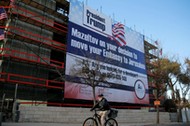 People walk past a giant banner on a building congratulating U.S. President-elect Donald Trump in Je