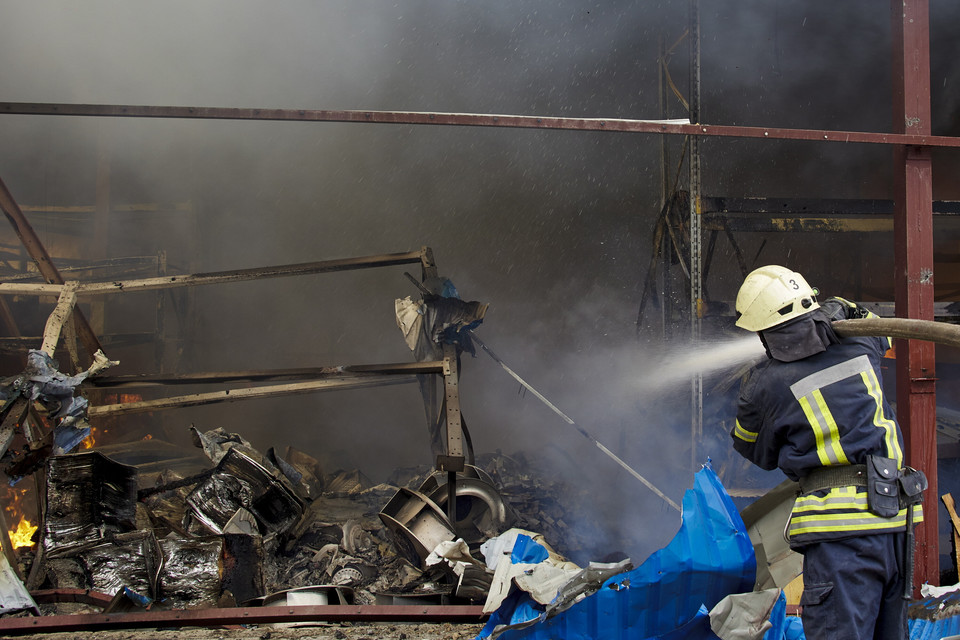 Strażacy pracują na miejscu pożaru po ostrzale w Charkowie