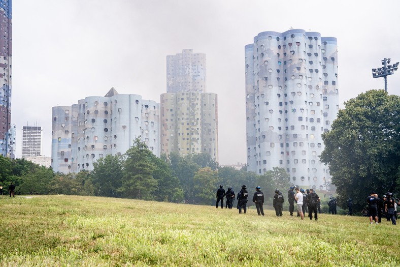 Grupa Policjantów w parku Andre Malraux w Nanterre na przedmieściach Paryża, gdzie zabito 17-letniego Nahela. W powietrzu unosi się chmura oparów z pojemników na śmieci i pozostałości gazu łzawiącego użytego do rozpędzenia uczestników zamieszek, do których doszło po śmierci chłopaka