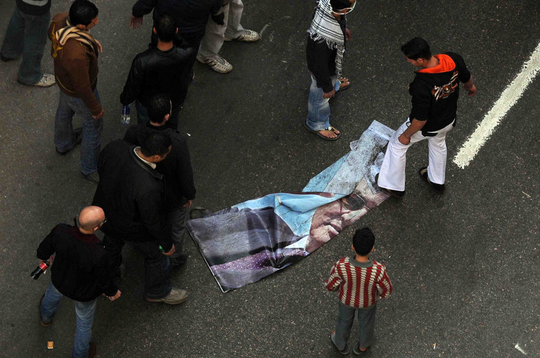 Egipt, Kair: Demonstranci depczą plakat z podobizną prezydenta Hosni Mubaraka. Fot. PAP/EPA