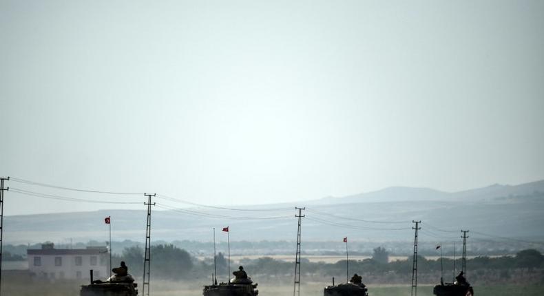 Turkish Army tanks drive to the Syrian Turkish border town of Jarabulus on August 25, 2016