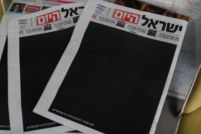 Egzemplarz gazety „Israel Hayom” (Israel Today) z zaczernioną pierwszą stroną i nagłówkiem w języku hebrajskim „Czarny dzień dla izraelskiej demokracji”, dzień po przyjęciu przez Kneset ustawy ograniczającej uprawnienia Sądu Najwyższego, Jerozolima, 25 lipca 2023.