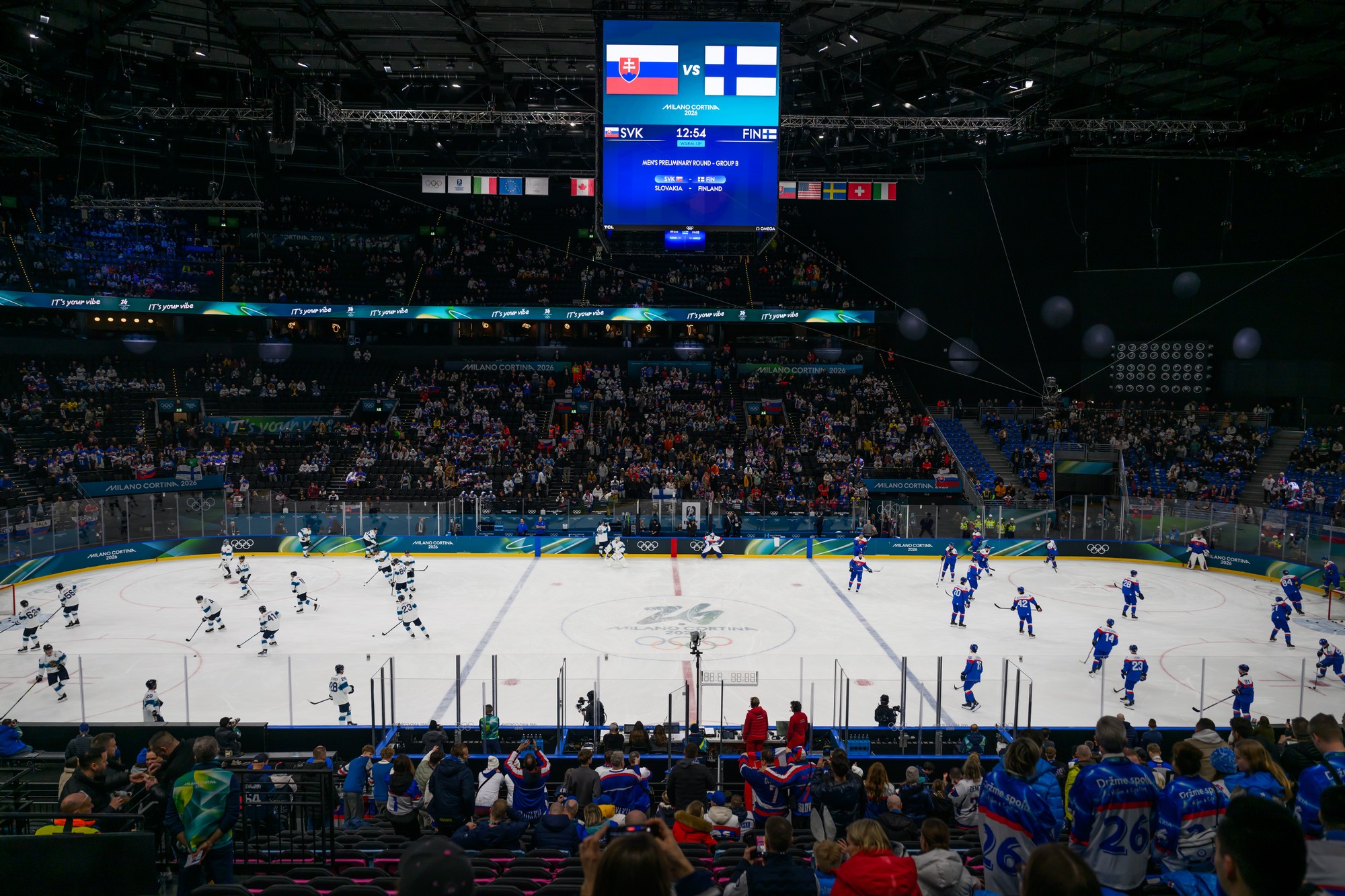 Tímy Slovenska (vpravo) a Fínska (vľavo) sa rozcvičujú na ľade pred zápasom. 