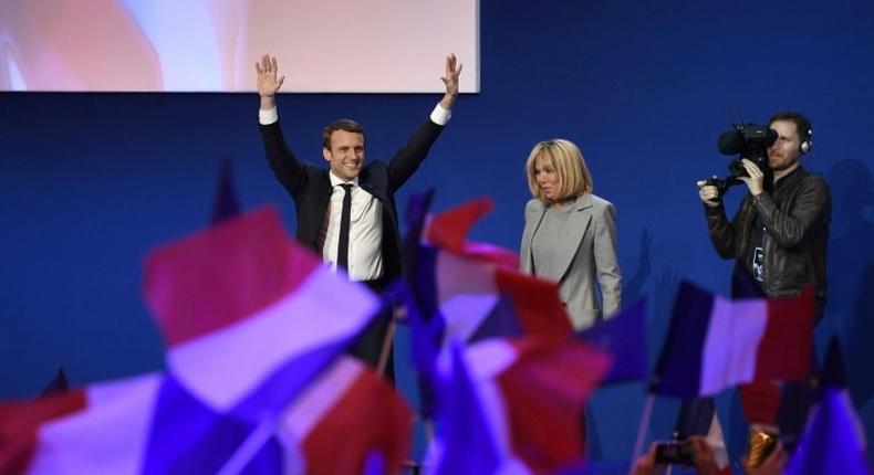 Emmanuel Macron and his wife Brigitte Trogneux salute the crowd after projections indicated the 39-year-old centrist led first round voting in France's presidential elections