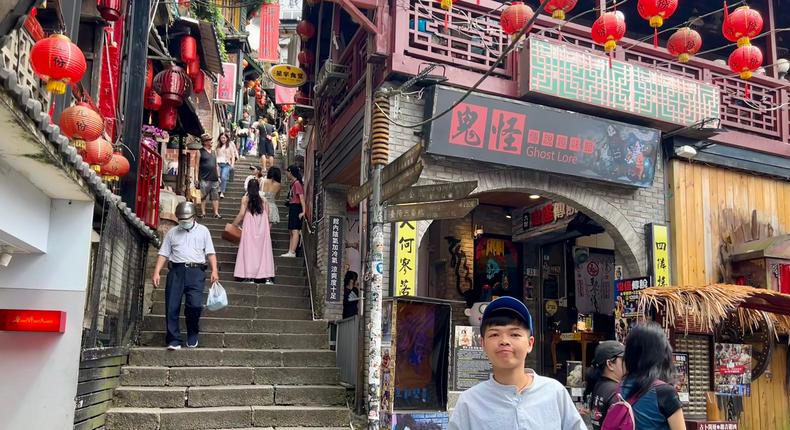 Mickey Tseng in her hometown of Jiufen, Taiwan — a former gold-mining town turned travel hot spot where many community spaces have been lost to tourism. Behind Tseng, a ghost lore museum has taken over shop spaces that once belonged to a shoe shop and a teahouse.Huileng Tan/Business Insider