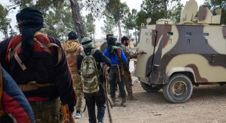 Rebel fighters queue to enter an armoured vehicle near the town of Bizaah northeast of the city of Al-Bab on February 4, 2017