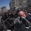 Palestinci oko automobila pogođenog u izraelskom napadu u gradu Gazi, 18. jun 2026.