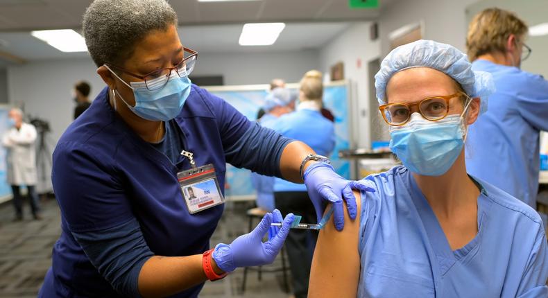 RN Janelle Roper, left, administers the Pfizer Covid-19 vaccine to Nurse Anesthetist Kate-Alden Hartman.
