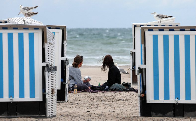 Plażowicze spędzają czas nad Morzem Bałtyckim mimo złej pogody.