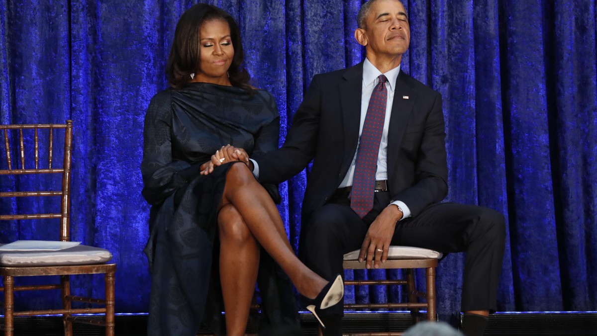 Former U.S. President Obama and first lady Michelle Obama hold hands prior to portraits unveiling at