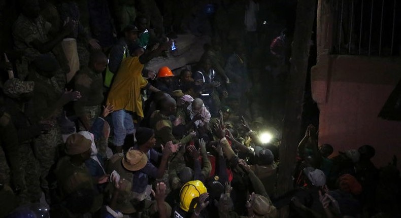 Volunteers evacuate a child rescued from the rubble of a six-storey building that collapsed after days of heavy rain, in Nairobi, Kenya April 30, 2016. 