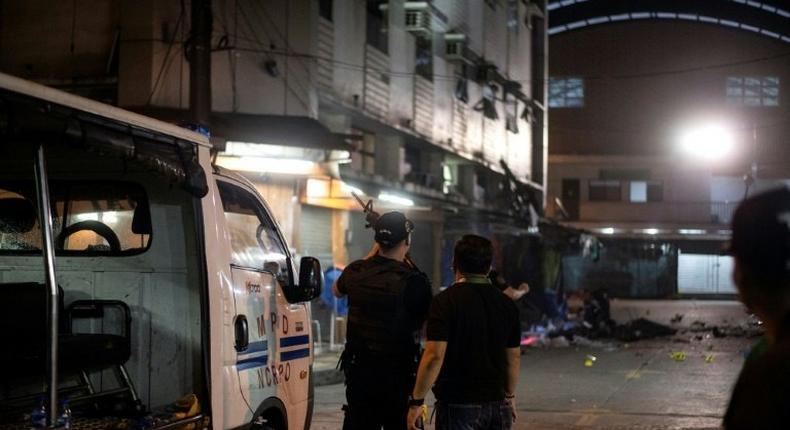 Philippines police officers look on just after an explosion in the Quiapo district of Manila, on May 6, 2017