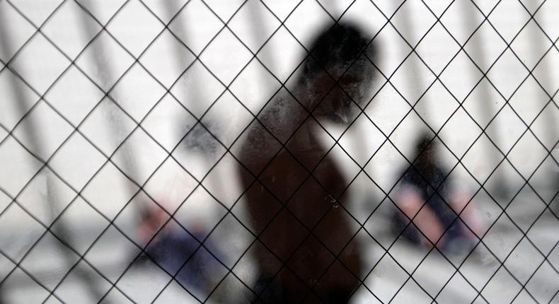 In this May 26, 2010 file photo, men sit in the sun in the health ward at the Otay Mesa immigration detention center in San Diego.
