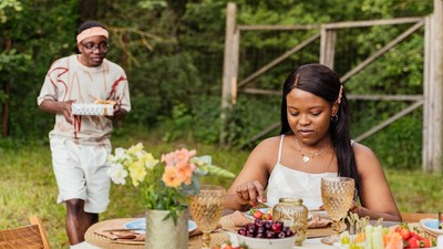 Couple on an outdoor date with the man holding a surprise gift [Image Credit: Antoni Shkraba Production]