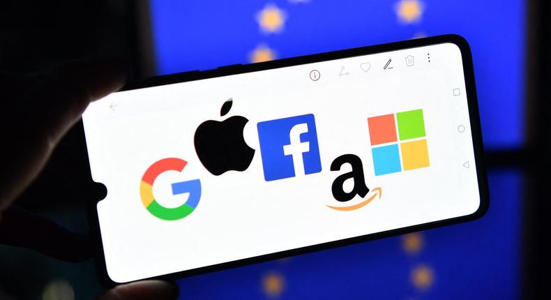 Google, Apple, Facebook, Amazon, and Microsoft logos displayed in front of an EU flag.JUSTIN TALLIS/AFP via Getty Images
