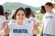 happy volunteer girl showing thumbs up sign