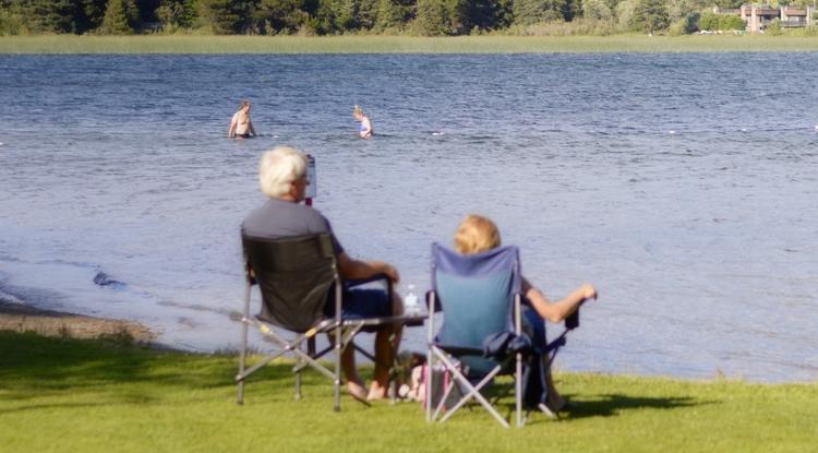 Nyugdíjasok ülnek egy tóparton
