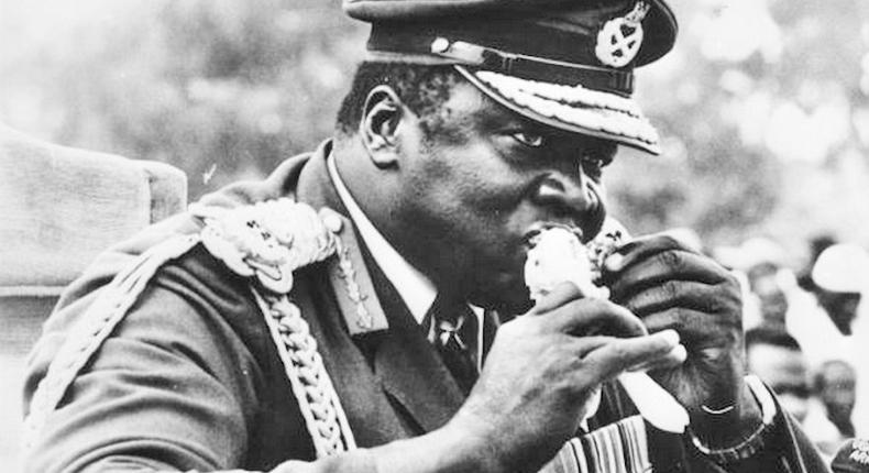 Ugandan dictator Idi Amin eating a piece of roast chicken at Koboko, Uganda, while watching a parade on the 7th anniversary of his military coup.