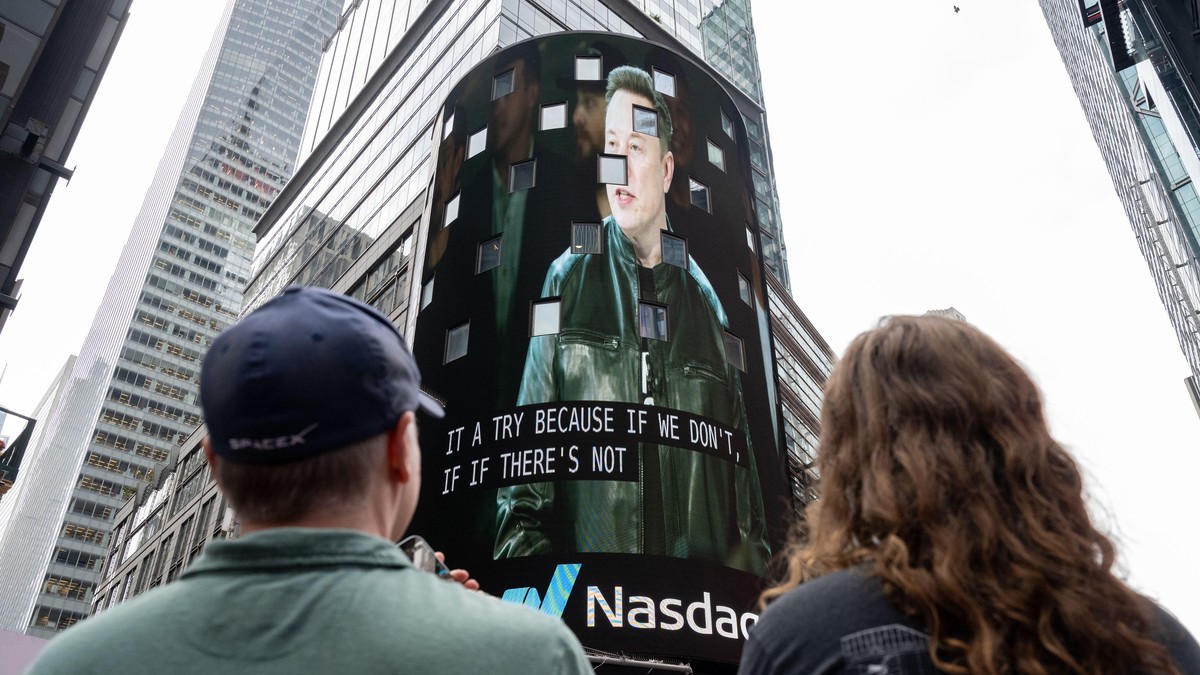 Posmatrači gledaju kako se na ekranu na Tajms skveru pojavljuje Ilon Mask, osnivač kompanije SpaceX, tokom inicijalne javne ponude akcija (IPO) kompanije u Nasdaq MarketSite centru, 12. juna 2026. godine u Njujorku.