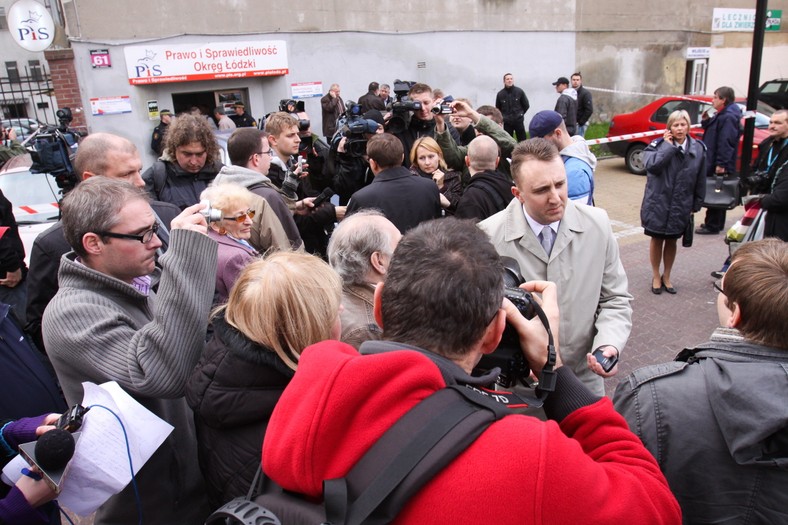 Poseł PiS Sławomir Worach (w popielatym płaszczu) rozmawia z dziennikarzami przed wejściem do siedziby łódzkiego biura Prawa i Sprawiedliwości. Fot. PAP/Rafał Goły