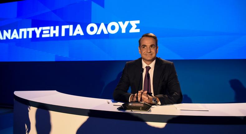 Greece's Prime Minister Kyriakos Mitsotakis waits for a news conference to start during the Thessaloniki International Fair at the northern city of Thessaloniki, Sunday, Sept. 8, 2019. Greece's prime minister said on Saturday that financial reforms such as reducing taxes, fighting bureaucracy and attracting investment must be implemented before the country asks its creditors to agree to lower budget surpluses. The slogan reads :