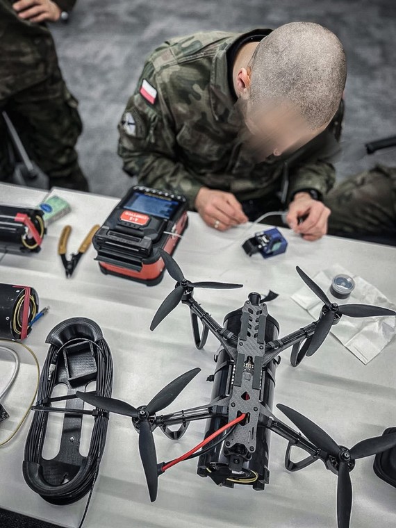 Żołnierz 1. WBP uczy się technik montażu drona.