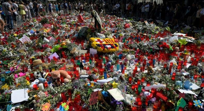 People lay flowers and candles to pay tribute to the victims of the Barcelona and Cambrils attacks on the Rambla boulevard in Barcelona on August 22, 2017